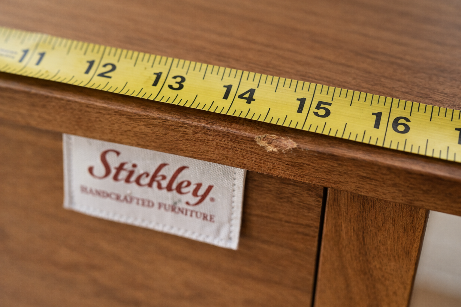 Used furniture value detail photo showing a tape measure and a close-up wear spot.